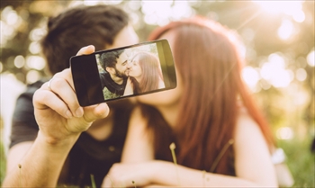 スマートフォンで自撮りをする男女