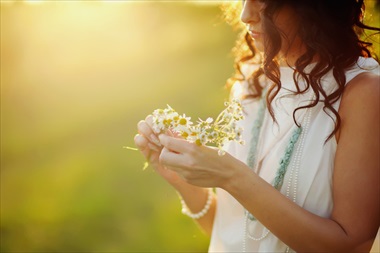 夕日の中で花を手にする女性
