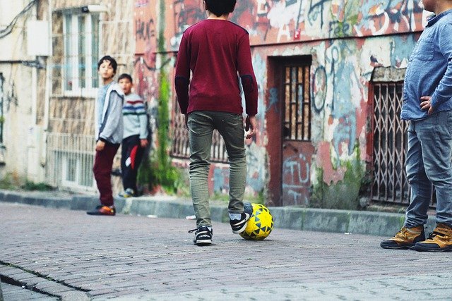 路地でボール遊びをする子どもたち