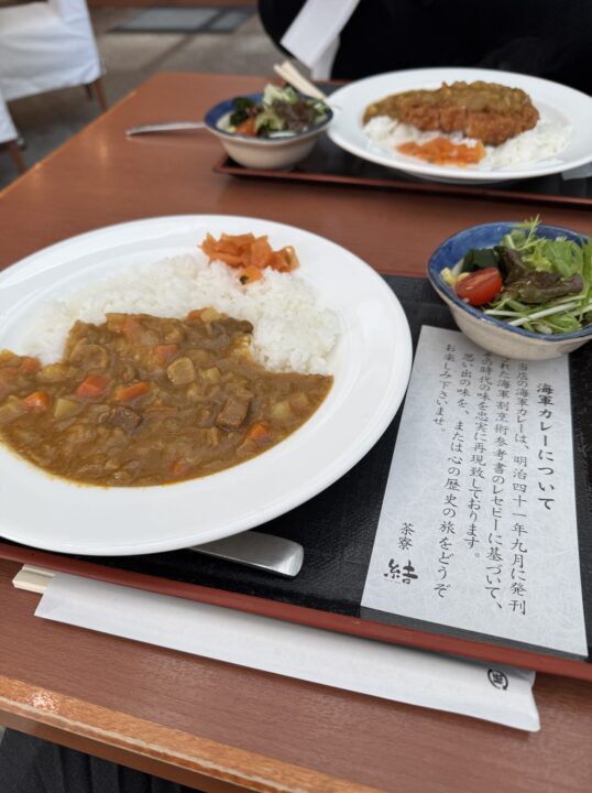 木のテーブルに並んだカレーとサラダ