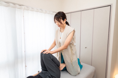膝まわりに手を添える魂蘇セラピーのボディワーク